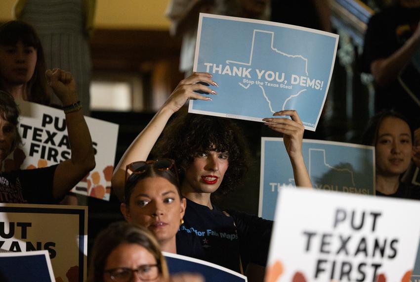 A crowd holds up signs as representatives walk into the Texas House on Aug. 18, 2025. Texas Democrats left the state to fight redistricting at the national level, returning after two weeks to resume work in the state.