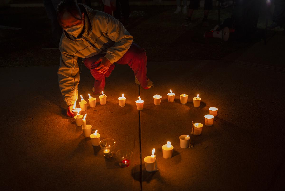 Qiongxia Lin prepares candles in a heart shape at the Grassy Knoll in Dallas to honor to the victims of the shootings in Atlanta. 