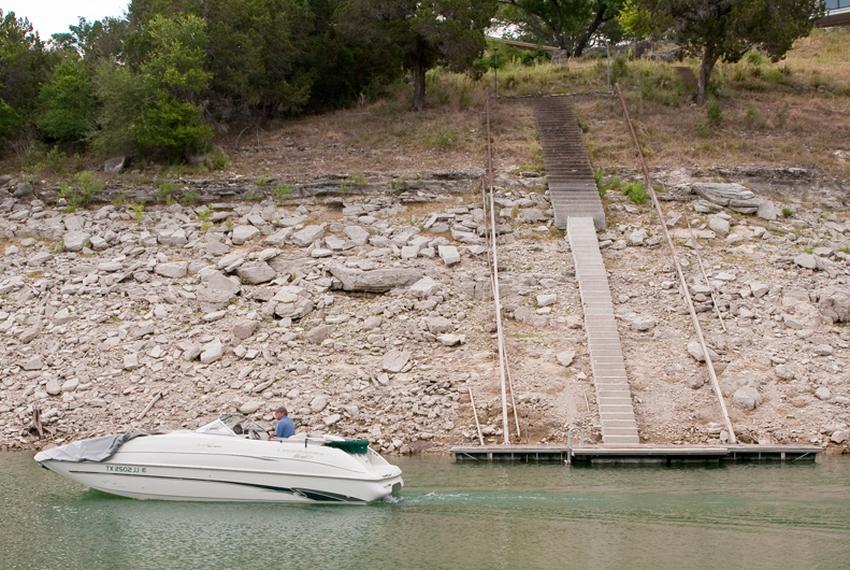 Residents of Lake Travis have extended staircases and moved docks further out to accommodate lower lake levels. Some say the declining levels are bringing down property values.