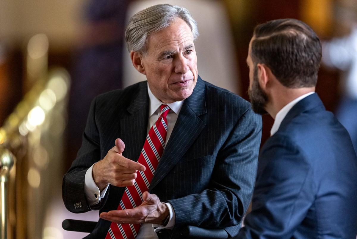 Gov. Greg Abbott speaks with lawmakers on the House floor during the legislative session on Sunday, May 23, 2021.