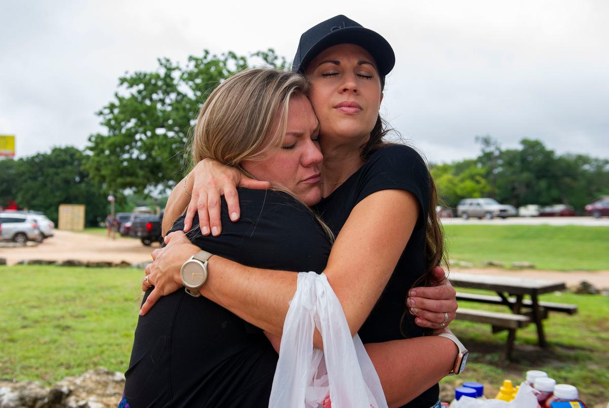 Kerrville resident Charity Hicks, 38, right, hugs a friend at a food and supply drop off station at Cross Kingdom Church Saturday July 5 2025, in Kerrville, Texas.