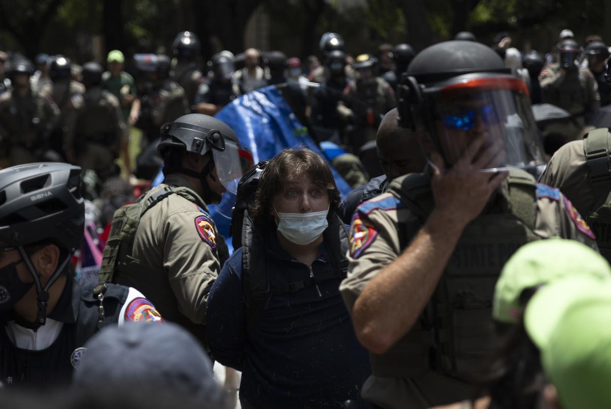 Law enforcement leads a pro-Palestinian protester away in custody as they begin to remove demonstrators from an encampment set up in support of Gaza on the UT-Austin campus on April 29, 2024.