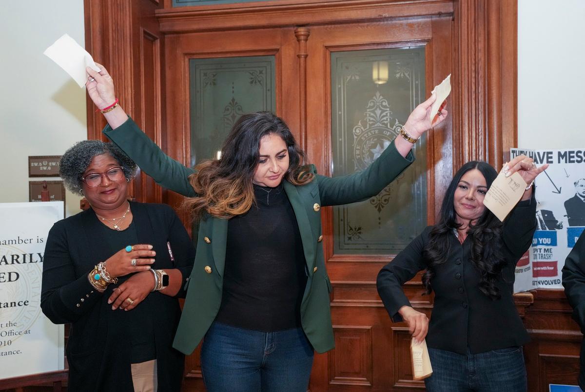 State Rep. Mihaela Plesa, D-Plano, rips up her "permission slip" in front of the Texas House vowing she will stay the night in the House Chamber in support of fellow Democrat Nicole Collier on August 19, 2025. At left is Rep. Rhetta Bowers, D-Garland, at right is Rep. Cassandra Hernandez, D-Farmer's Branch.