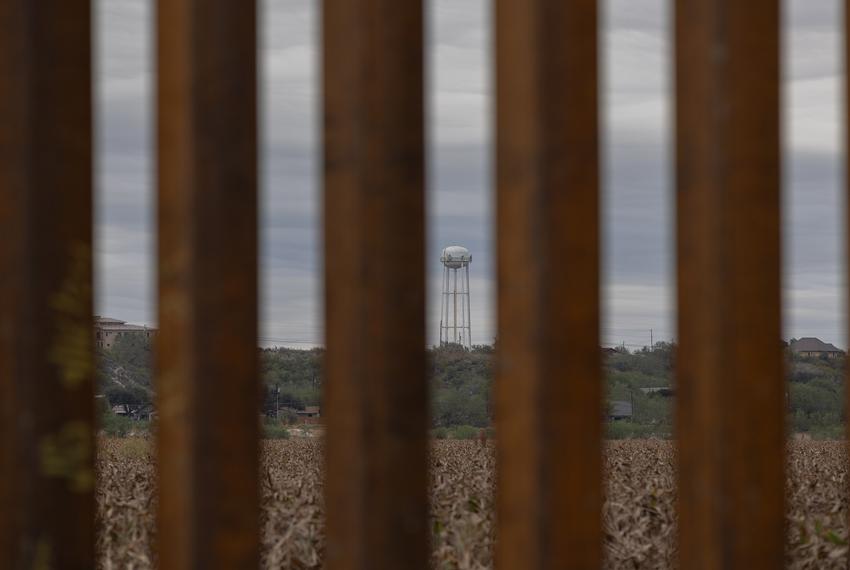 A Union Water Supply Corporation and a neighborhood is seen through border wall slats prior to a General Land Office news conference held at a state-acquired ranch in Rio Grande City on Tuesday, Nov. 26, 2024. Buckingham promised Texas would provide the incoming Trump administration more land to stage mass deportations.