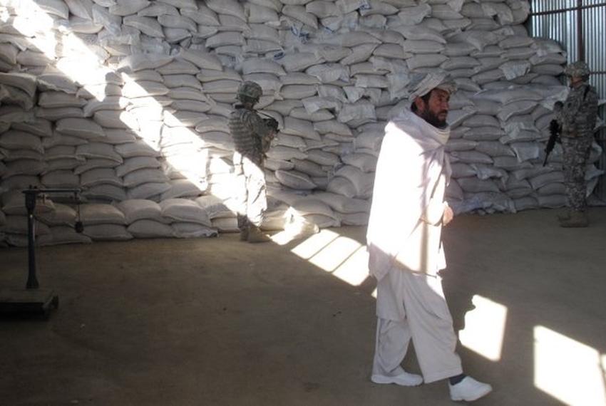 The ADT assists on agricultural development projects in Ghazni such as this warehouse. Here the contractor and a supervisor wait while the ADT does the final inspection. ADT security soldiers stand guard at the rear. 