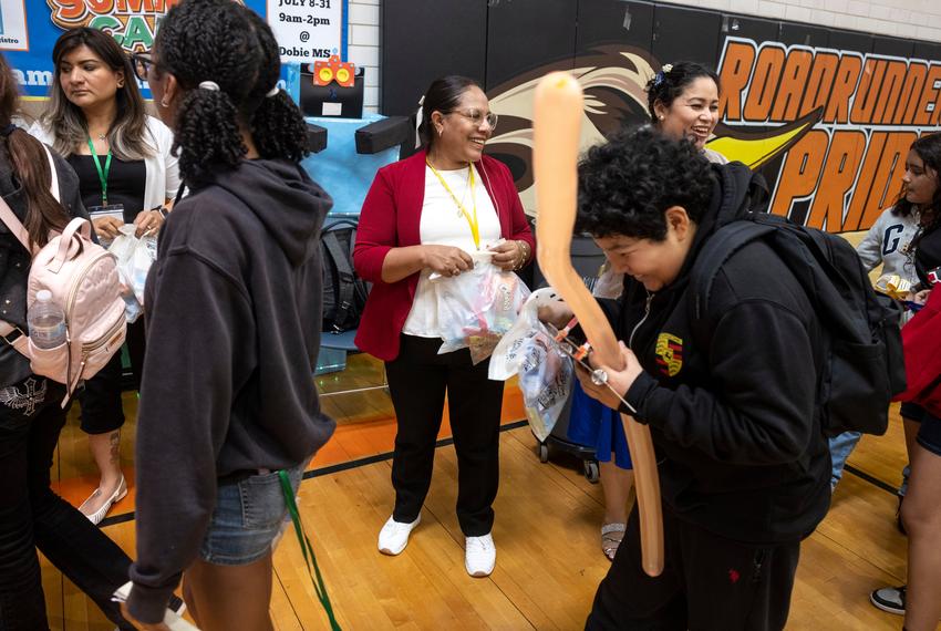 AUSTIN, TEXAS - July 24, 2025: Carmen Mendoza hands out gift bags to campers as they head home. Austin Voices for Education and Youth hosts a summer camp at the Dobie Middle School for students that attend the three Austin ISD schools at risk of closure. Ilana Panich-Linsman for The Texas Tribune