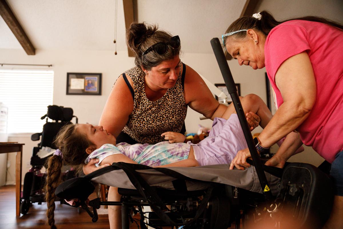 Kari and Laurie adjust Logan's position on a sling on Sep. 9, 2023.