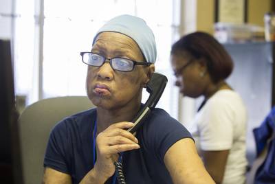 Realtor Pamela Banks makes a call in her office in Houston on April 19, 2018. Seated by her her is one of her clients, Denise Taylor, who has a federal Section 8 housing voucher but has been unsuccessful finding a place to live.
