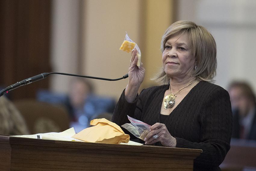 State Rep. Helen Giddings, D-Desoto, holds up a sample of a piece of cheese given to students who lack money to pay for school lunches in Dallas area schools during a personal privilege speech on the House floor May 9, 2017, where she chastised House Freedom Caucus members for killing her bill on school lunches for poor kids. 