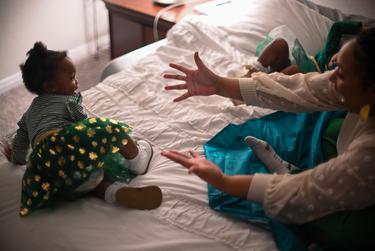 Alexandria Robertson reaches for her daughter Kellani-Ari Wilson in her bedroom in Manor, TX, on Feb. 2, 2023.