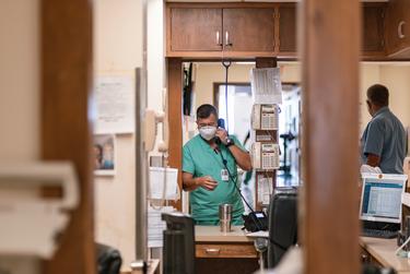 Charge Nurse Mason Hickam, RN, answers the phone at the nursing station at Goodall-Witcher Hospital in Clifton on Aug. 3, 2021.