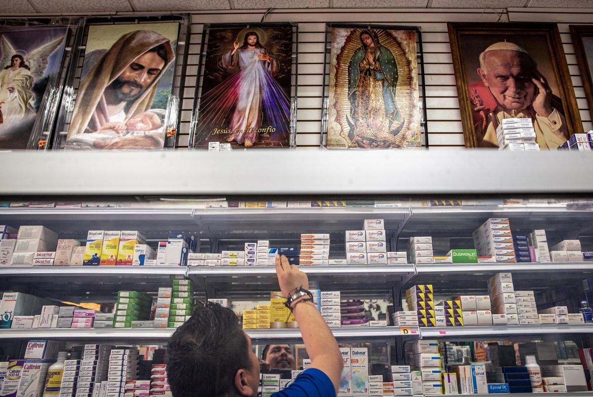 Victor Olvera puts two pharmaceutical drugs meant to be taken for ulcers back on the shelf at the Uncle Sam Pharmacy in Nuevo Progreso, Mexico on May 4, 2022.