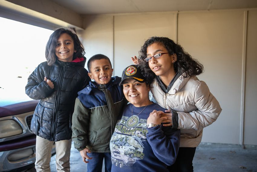 Frances Sanchez and her three children (from left) Samaria or Sammy Sanchez, 9, Pedro Sanchez, 6, and Katrina Sanchez, soon to be 13, pose for a portrait in the home of a friend where they are staying in Garland.