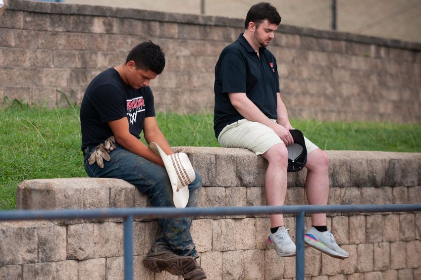People pray during a Kerr County Blessing at Antler Stadium on Wendsday July 9, 2025 in Kerrville, Texas. The event started off with a worship and prayer followed by a social gather on the field afterwards.