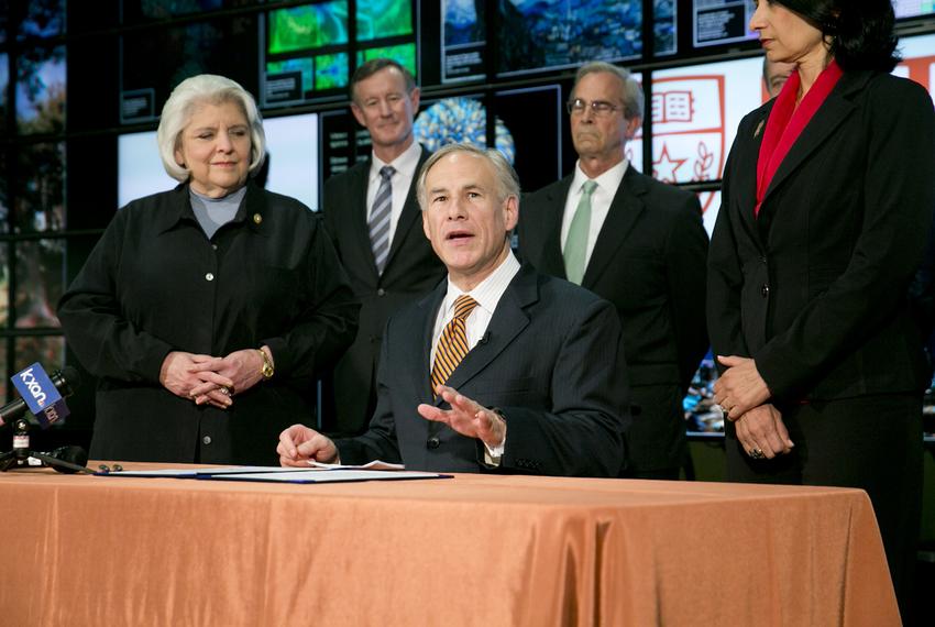 Gov. Greg Abbott signs several higher education related bills into law on June 4, 2015. He also praised state Sen. Judith Zaffirini, left, for her work in the most recent legislative session on education issues.