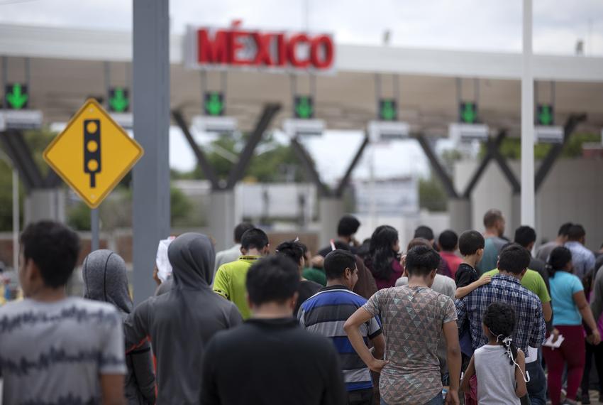 A group of migrants walk across International Bridge Two into Mexico from the United States. The group requested asylum in the United States, but were returned to Mexico to await their court proceedings. July 23, 2019.