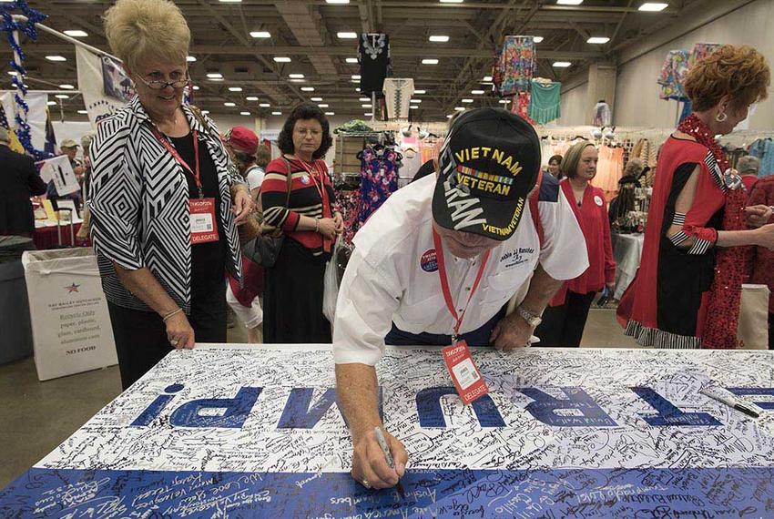 Vietnam veteran Jim Faulkner of Calhoun County signs a Trump for President banner at the Republican Party of Texas event in Dallas May 13, 2016.