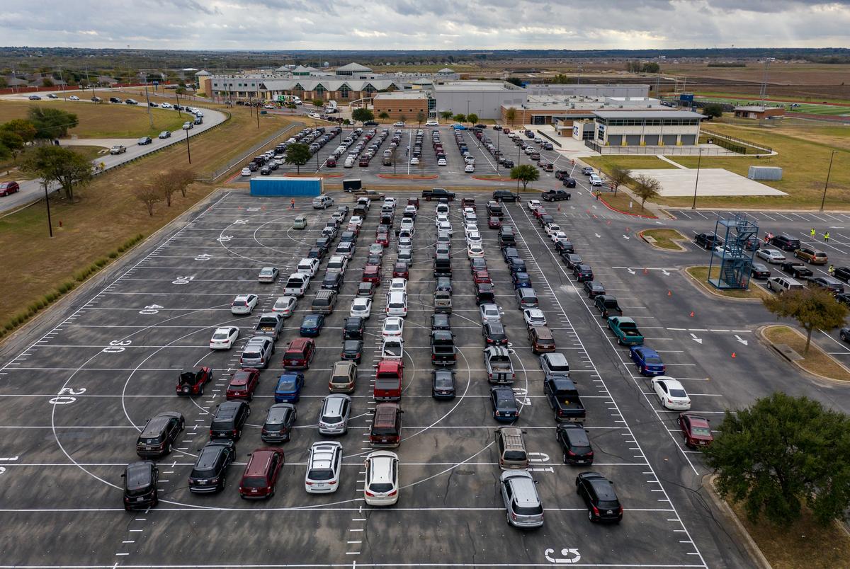 Hundreds of cars line up in the parking lot of Lehman High School in Kyle to receive food from the Central Texas Food Bank.
