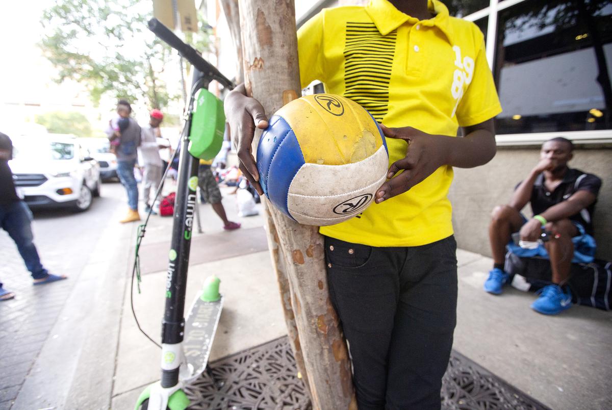 Children read and play outside a makeshift center  on June 26, 2019. Large groups of migrants, mostly from Africa have been arriving to somewhat makeshift shelters in downtown San Antonio