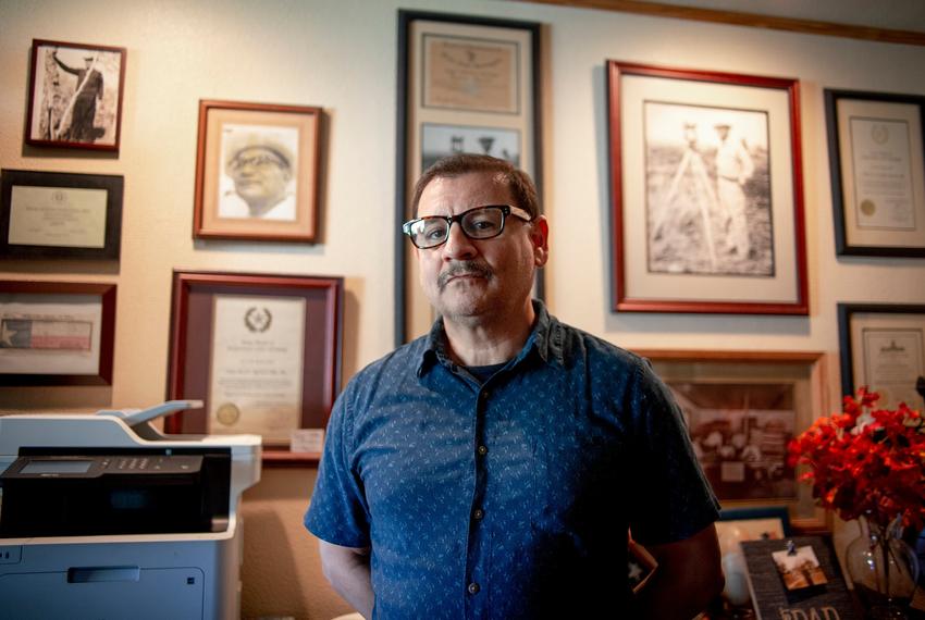 Land surveyor and Republican voter Ernesto Alanis III stands amongst a wall showcasing his business’ history in Rio Grande City on Nov. 9, 2020.