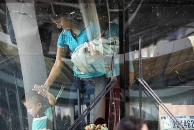 A young boy is escorted off of an immigration bus by a woman at the McAllen Central Station in downtown McAllen on June 25, 2019.